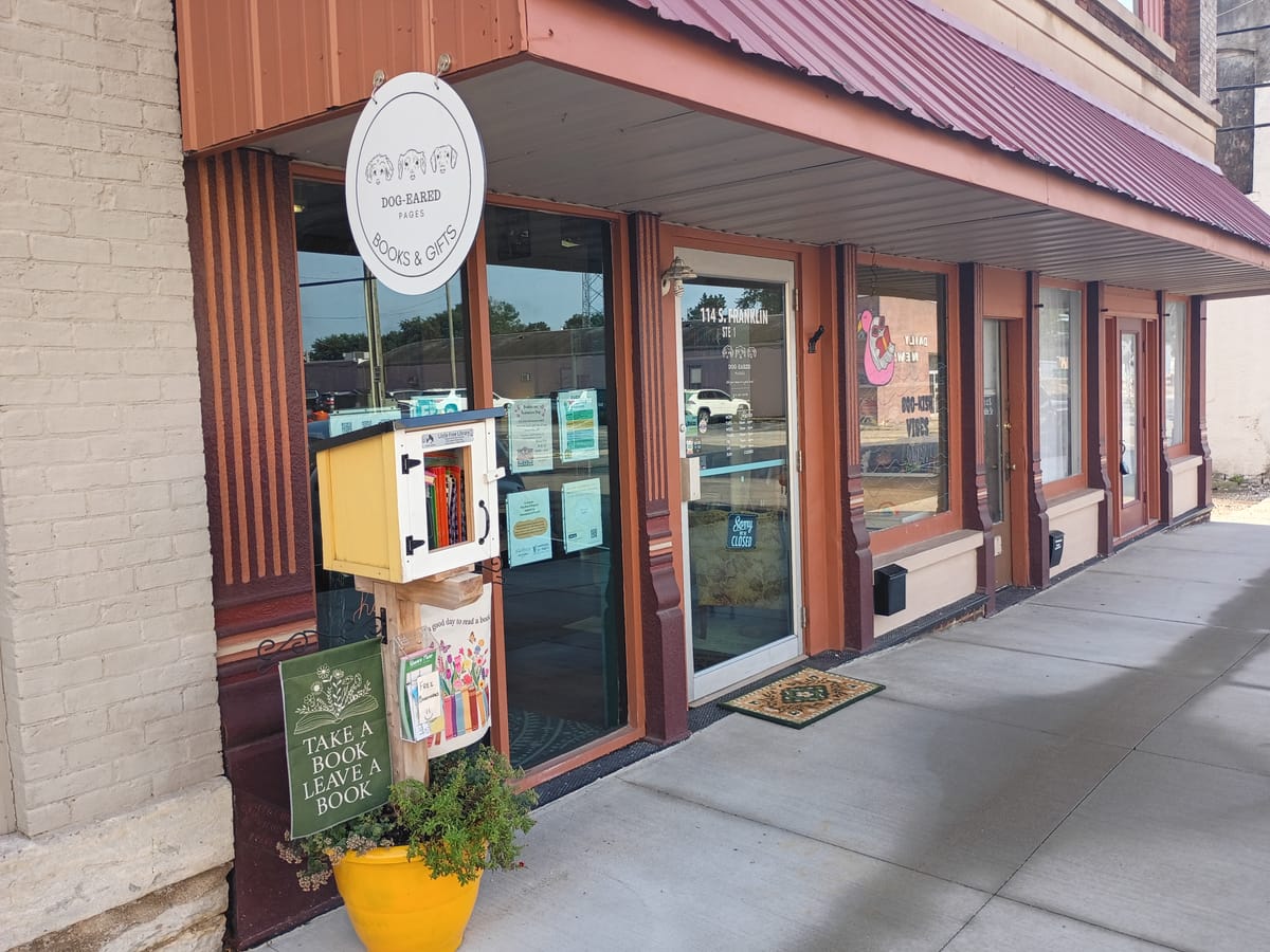 Street view of Dog-Eared Pages, 114 S. Franklin St. Greensburg, IN. There's a small Little Free Library box out front and Halloween-themed art in the windows. Photo by Noelle Maxwell.