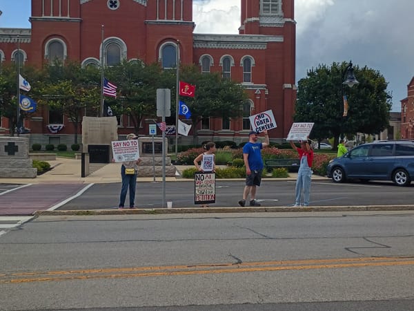 A crowd of four protestors against a proposed AI data center gathered along Main Street in downtown Greensburg Saturday, July 18. Photo by Noelle Maxwell.